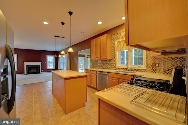 kitchen with light brown cabinetry, sink, a center island, stainless steel appliances, and decorative backsplash