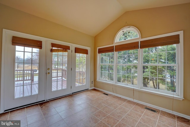 unfurnished sunroom with vaulted ceiling, a healthy amount of sunlight, and french doors