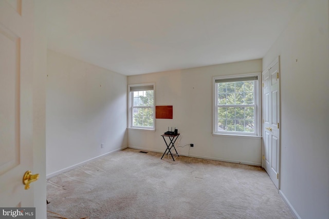 unfurnished room featuring light colored carpet