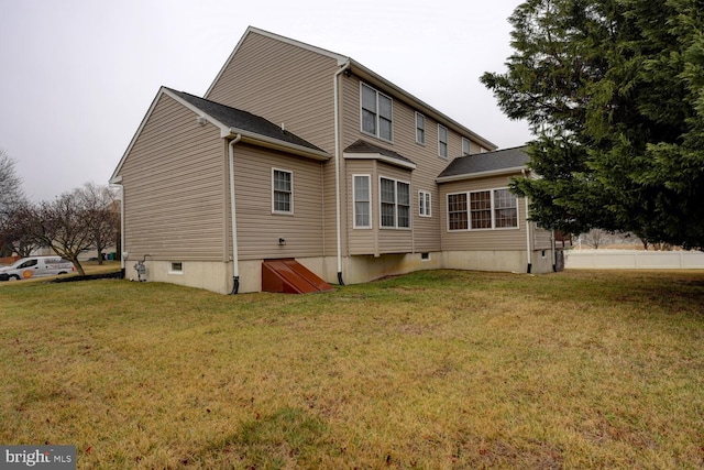 rear view of property with a lawn