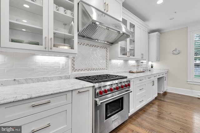 kitchen with white cabinetry, designer stove, light stone countertops, and decorative backsplash