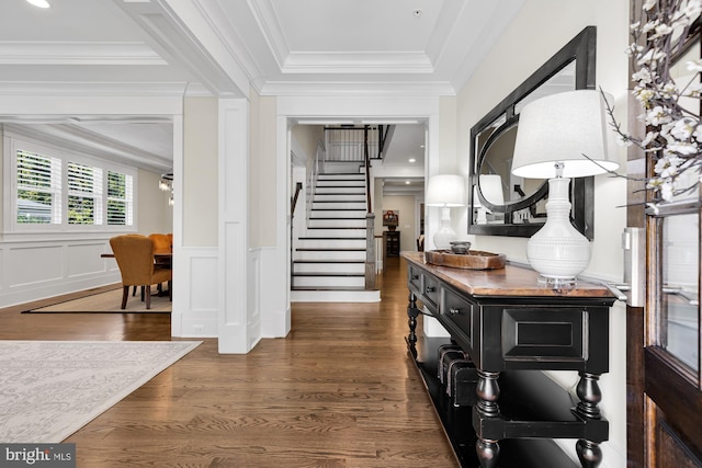 entryway with dark wood-type flooring and ornamental molding