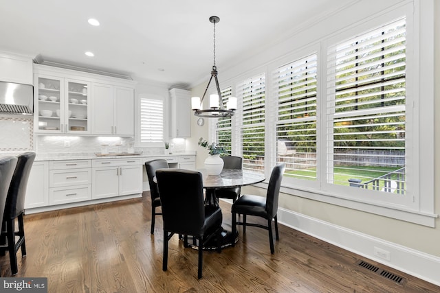 dining space featuring ornamental molding, dark hardwood / wood-style floors, and a chandelier