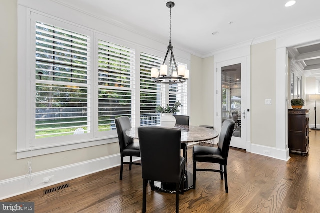 dining room with ornamental molding, dark hardwood / wood-style floors, and a chandelier