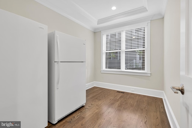 kitchen featuring crown molding, white fridge, wood-type flooring, and a tray ceiling