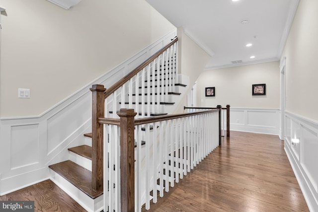 stairway with crown molding and hardwood / wood-style floors