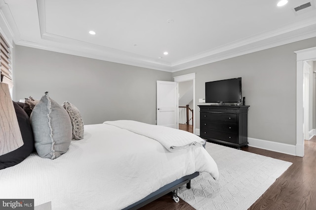 bedroom with crown molding and dark hardwood / wood-style flooring