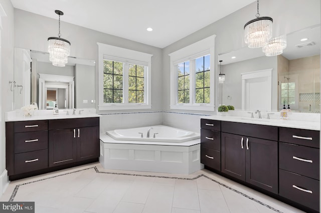 bathroom featuring vanity, plus walk in shower, a chandelier, and tile patterned flooring