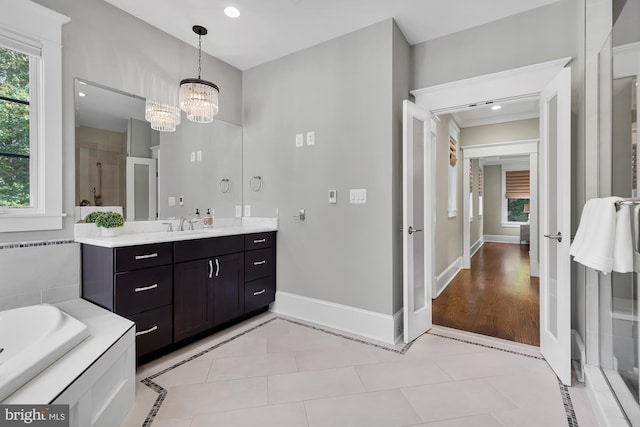 bathroom with vanity, tile patterned flooring, independent shower and bath, and a chandelier