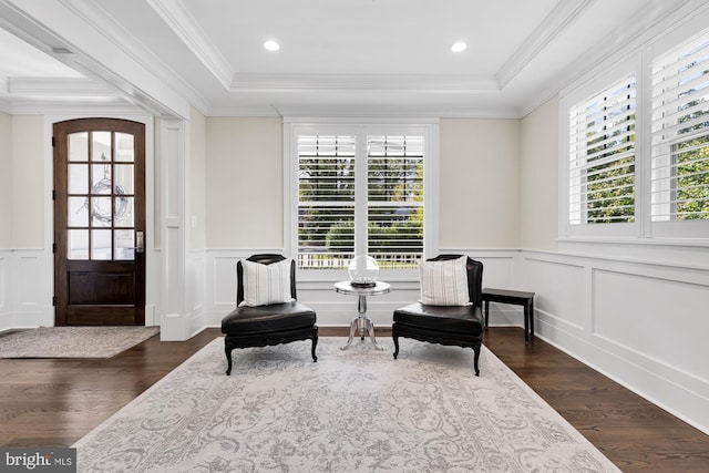 living area featuring crown molding, dark hardwood / wood-style floors, and a raised ceiling