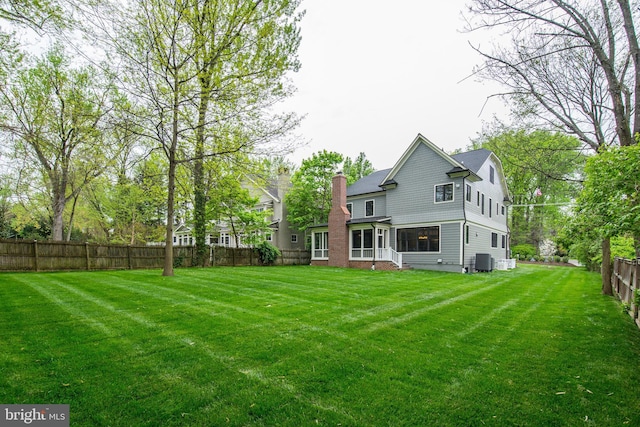 back of house with central AC and a yard