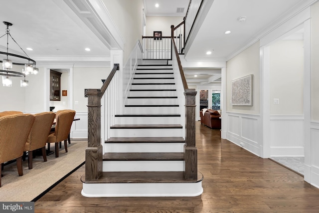 stairway featuring crown molding and wood-type flooring