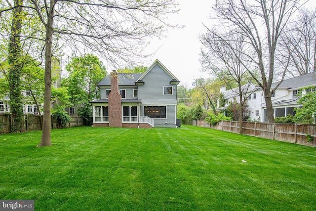 rear view of property featuring a lawn