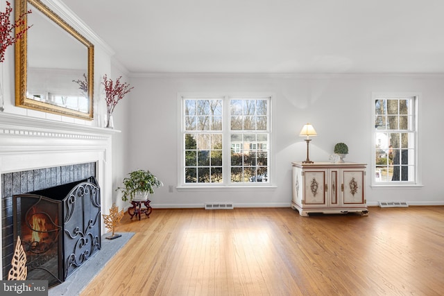 living room with crown molding and light hardwood / wood-style floors