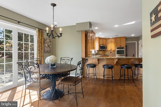 dining room with an inviting chandelier and dark hardwood / wood-style flooring