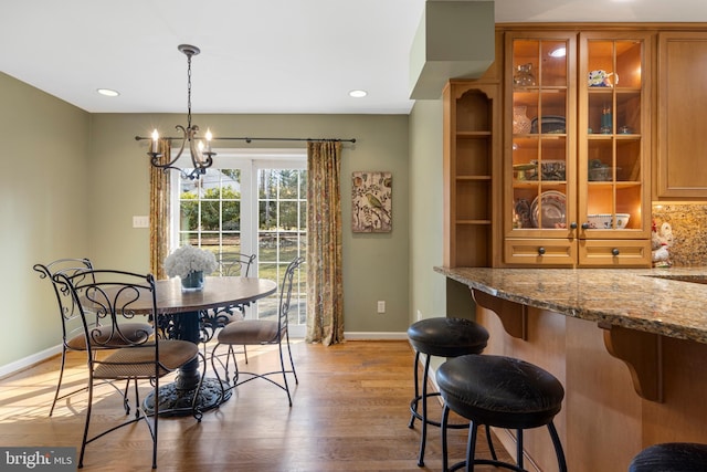 dining area with a chandelier and light hardwood / wood-style flooring