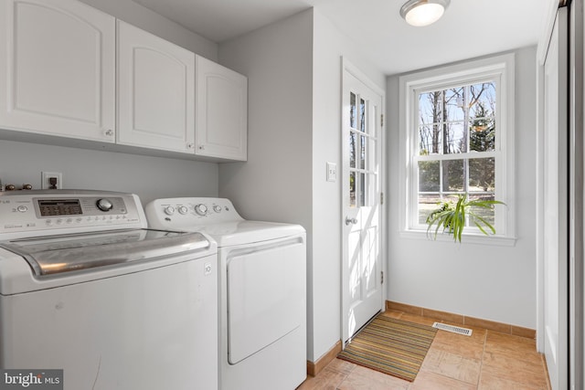 washroom with cabinets and washer and dryer