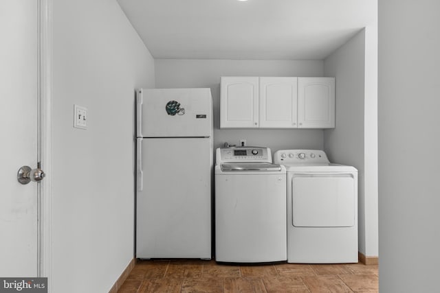 washroom featuring washer and dryer and cabinets