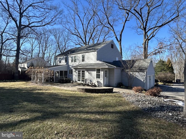 back of house with a garage, a patio area, and a lawn