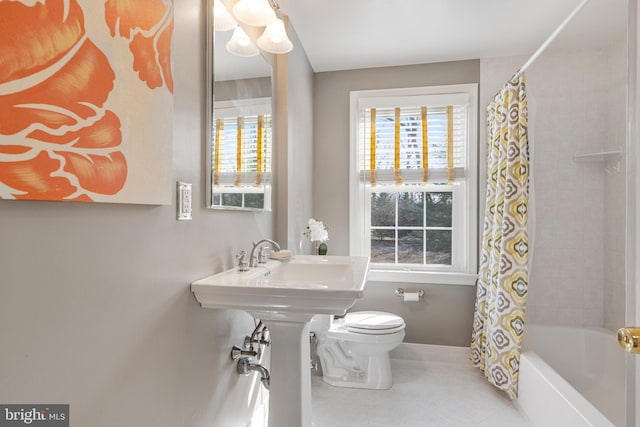 bathroom featuring a healthy amount of sunlight, toilet, tile patterned flooring, and shower / bath combo