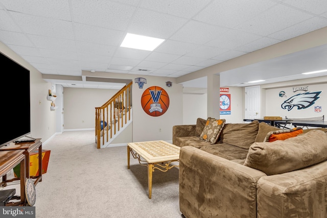 carpeted living room featuring a drop ceiling