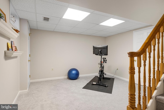 exercise room with carpet flooring and a drop ceiling