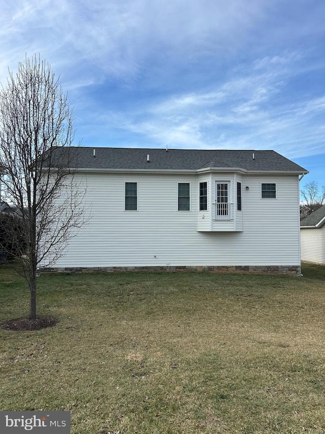 view of side of home with a yard