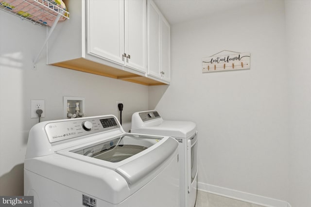 clothes washing area with cabinet space, baseboards, and separate washer and dryer