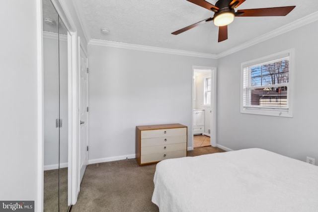 bedroom with a textured ceiling, connected bathroom, carpet floors, baseboards, and crown molding