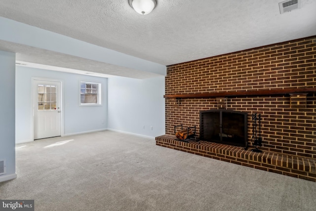 unfurnished living room featuring carpet flooring, visible vents, a textured ceiling, and baseboards