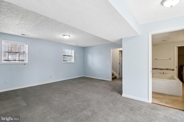 interior space featuring a textured ceiling, visible vents, and baseboards