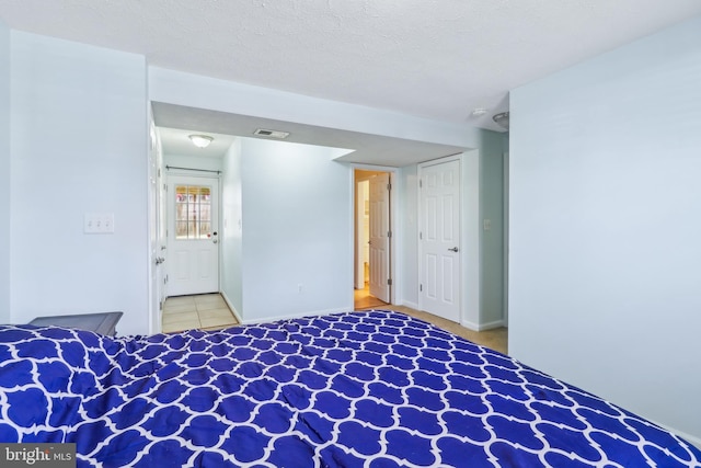 unfurnished bedroom featuring baseboards, visible vents, and a textured ceiling