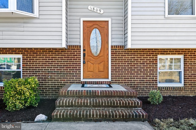 property entrance featuring brick siding