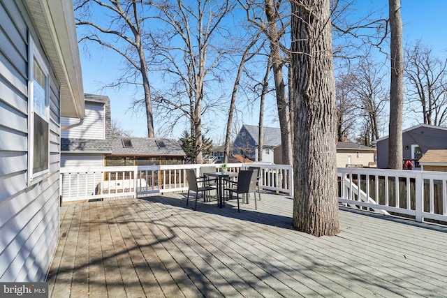 wooden terrace featuring a residential view and outdoor dining area