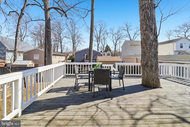 wooden terrace with a residential view and outdoor dining area