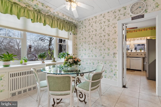 tiled dining area with ornamental molding and ceiling fan