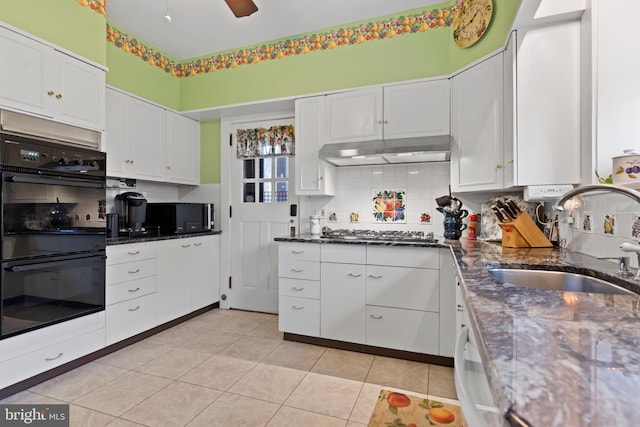 kitchen with sink, backsplash, white cabinets, black double oven, and stainless steel gas cooktop