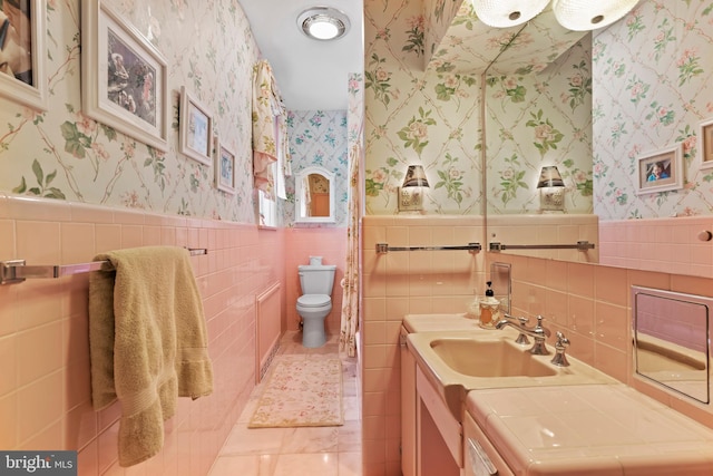 bathroom with washer / clothes dryer, vanity, and toilet