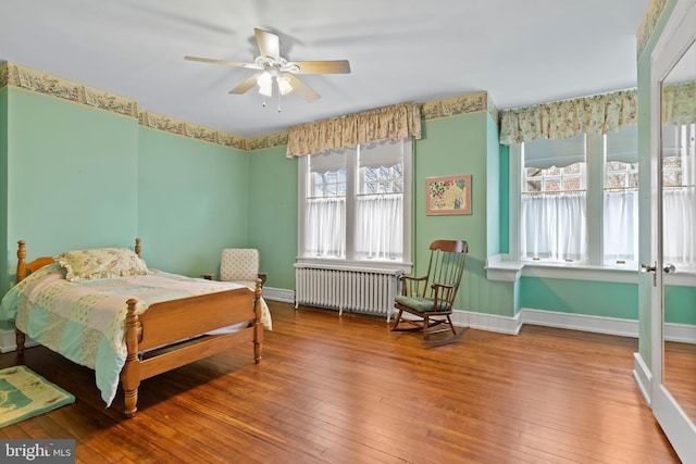 bedroom featuring radiator and hardwood / wood-style floors