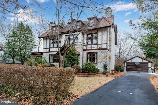 english style home with a garage and an outbuilding