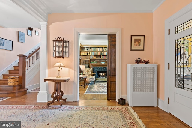 foyer entrance featuring crown molding, hardwood / wood-style floors, and decorative columns