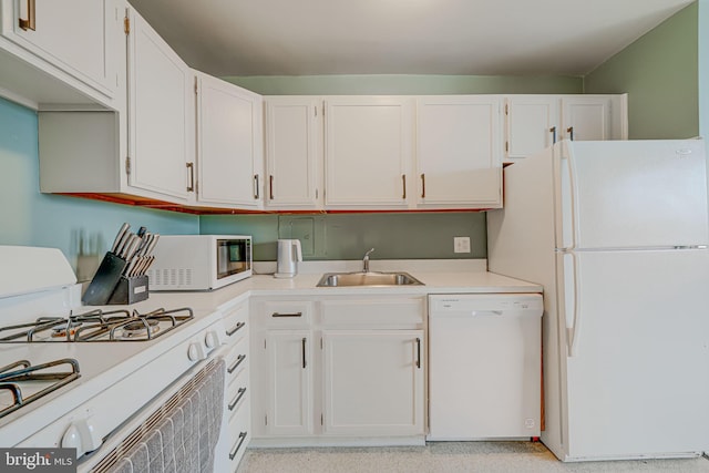 kitchen featuring white appliances, sink, and white cabinets