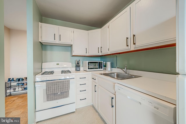 kitchen featuring white appliances, sink, and white cabinets