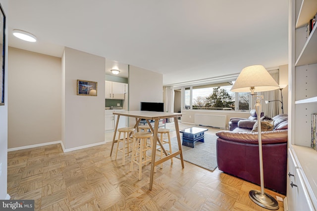 living room featuring light parquet flooring and radiator