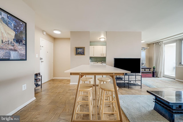 kitchen featuring a breakfast bar, light parquet floors, and white cabinets