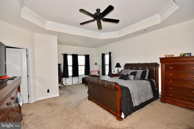 carpeted bedroom featuring crown molding, ceiling fan, and a tray ceiling