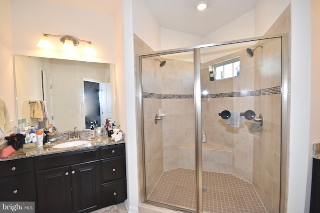 bathroom with vanity, vaulted ceiling, and a shower with door