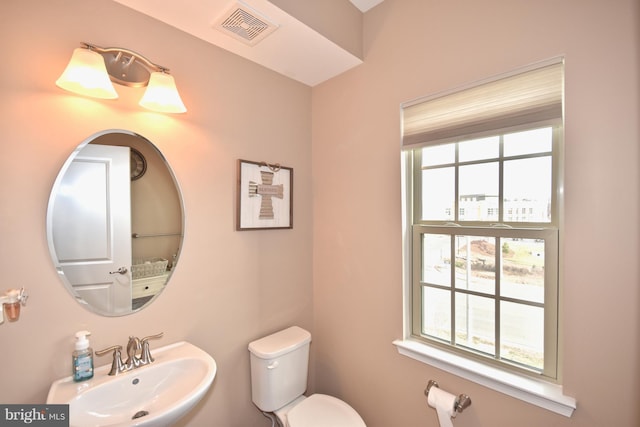 bathroom featuring a healthy amount of sunlight, sink, and toilet