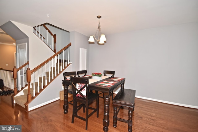 dining area featuring hardwood / wood-style flooring and an inviting chandelier