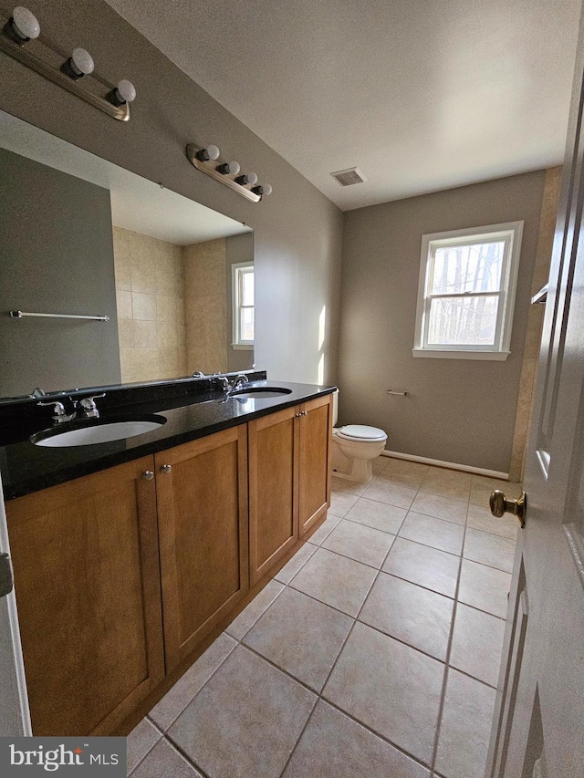 bathroom featuring vanity, plenty of natural light, tile patterned floors, and toilet